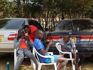 Kipchoge (seated) looking at his phone