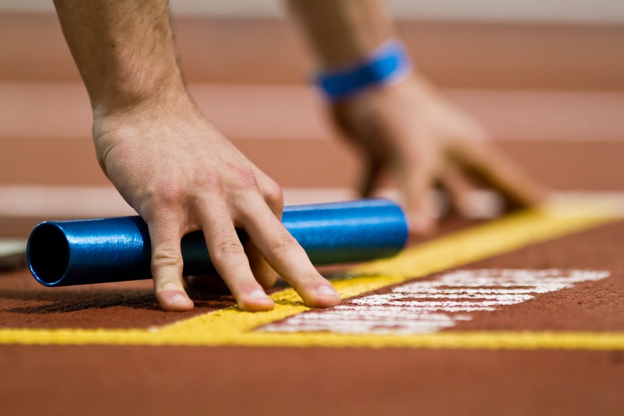 Millrose Games indoor track and field sprinter with relay baton at start