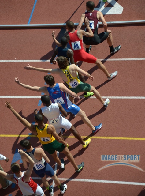 Runners wait for the handoff in the exchange zone in a college mens 4 x 400m relay heat