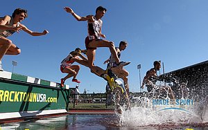 Jun 12, 2015; Eugene, OR, USA; Mason Ferlic of Michigan (17) falls in the water jump in the steeplechase in the 2015 NCAA Track & Field Championships at Hayward Field.