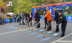 The ceremonial painting of the blue and yellow lines at the finish of the 2013 ING New York City Marathon. New York Road Runners president and CEO Mary Wittenberg is fifth from the left; to her immediate left is Tom Grilk, executive director of the Boston Athletic Association (photo by Chris Lotsbom for Race Results Weekly)