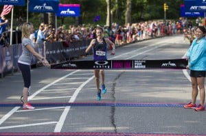 Molly Huddle, 29 of Providence RI, sets a new American 10K record (womenÕs only race) winning the Oakley New York Mini 10K with a time of 31:37 in Central Park on Saturday, June 14, 2014. Tape holders: Adrianne Haslet-Davis (left, dancer and Boston bombing survivor) and Esther Moy (right, Oakley). Courtesy NYRR.
