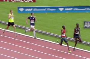 Kiprop and Amos Battle while a guy in a soccer uniform chases them.