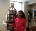 Emma Bates at the offices of the Boston Athletic Association with the Boston Marathon trophy (Photo by Chris Lotsbom for Race Results Weekly)