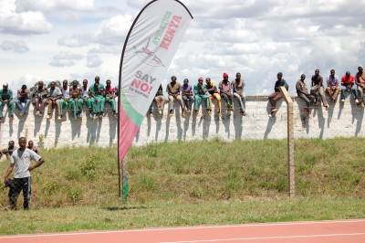 Spectators watch the Eldoret meeting from atop a wall outside the track