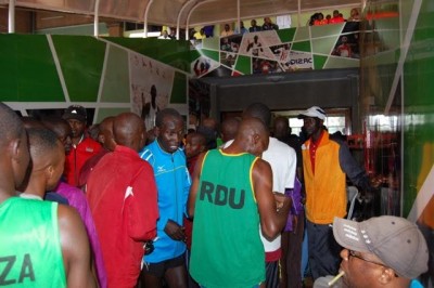 Athletes huddle under cover while rain pours down on Kasarani Stadium