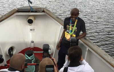 Mo Farah shows off one of his 2016 Olympic gold medals to photographers in advance of the 2016 Great North Run (photo by David Monti for Race Results Weekly)