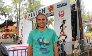 Hamish Carson proudly display's his 2016 Honolulu Marathon finisher's T-shirt (photo by Chris Lotsbom for Race Results Weekly)