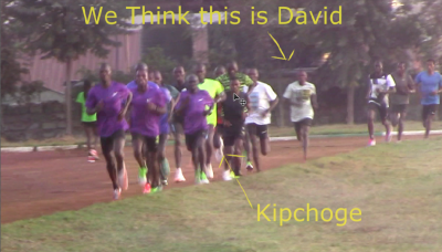 You can make out Kipchoge's white shoes, but his read top is largely obscurred in our photo. David has no shoes and is 20 meters back