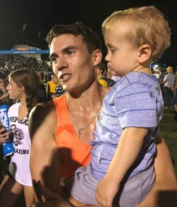 Chris O'Hare holds his son Ronan after winning the 2018 Hoka One One Long Island Mile in 3:55.53 (photo by David Monti for Race Results Weekly)