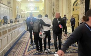 Kamworor being helped through lobby after Boston 2022